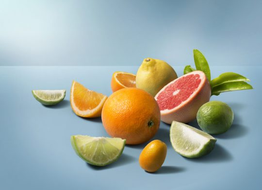 A group of mix citrus fruits on clean blue background. Studio shot image.